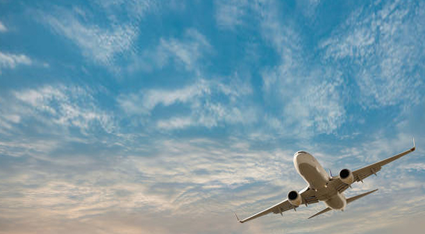 Commercial airliner on the tarmac beneath a dramatic evening sky